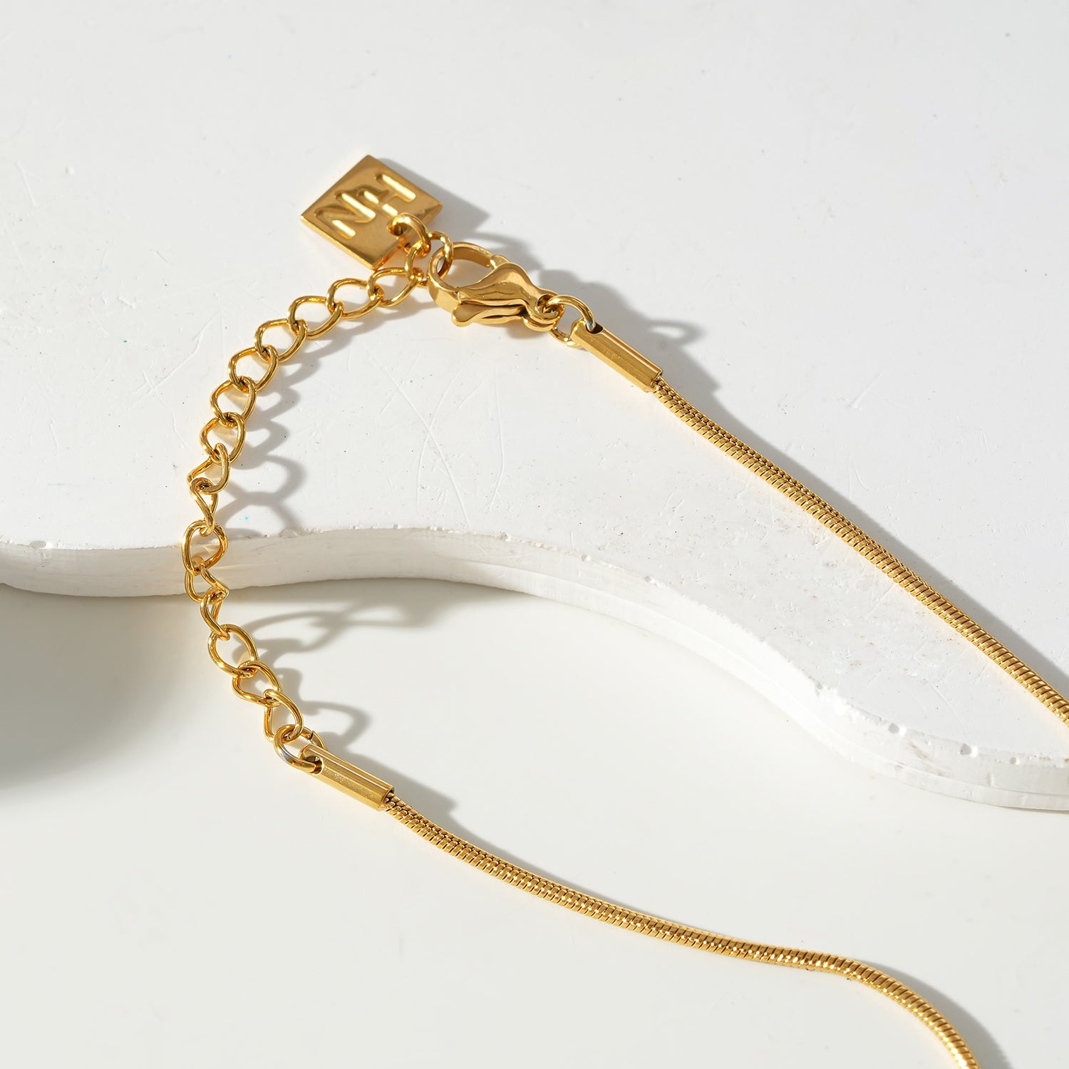 JASPUR: Snakeskin Chain Necklace with Love-Knot Pendant in Gold